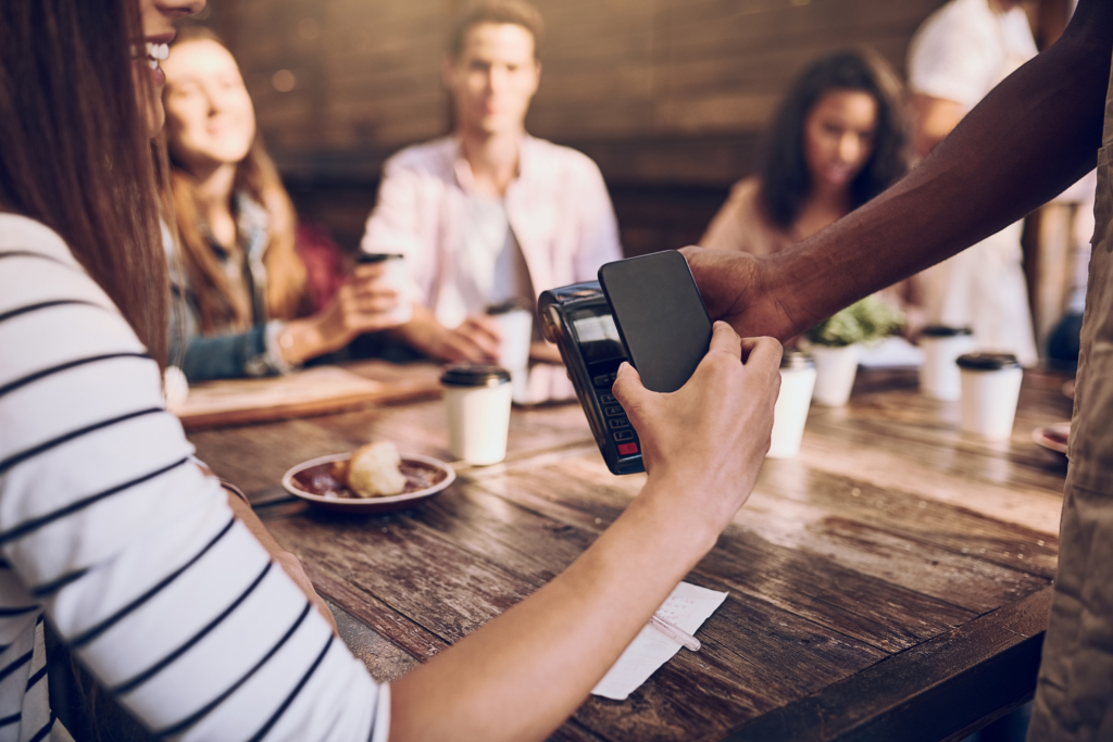 Person, phone and restaurant for payment with mobile app, pos machine and bill for lunch or meal in cafe. People, service and scanning tech as customer in cashless transaction in sale for ecommerce.
